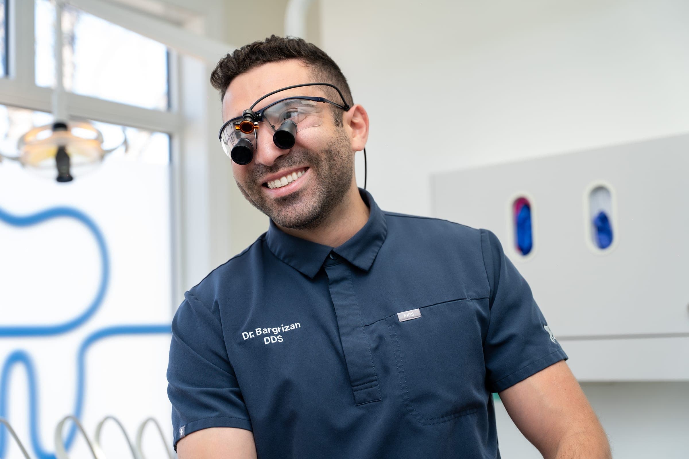 Dr. Bargrizan, a Dental Choice dentist, smiling in a treatment room