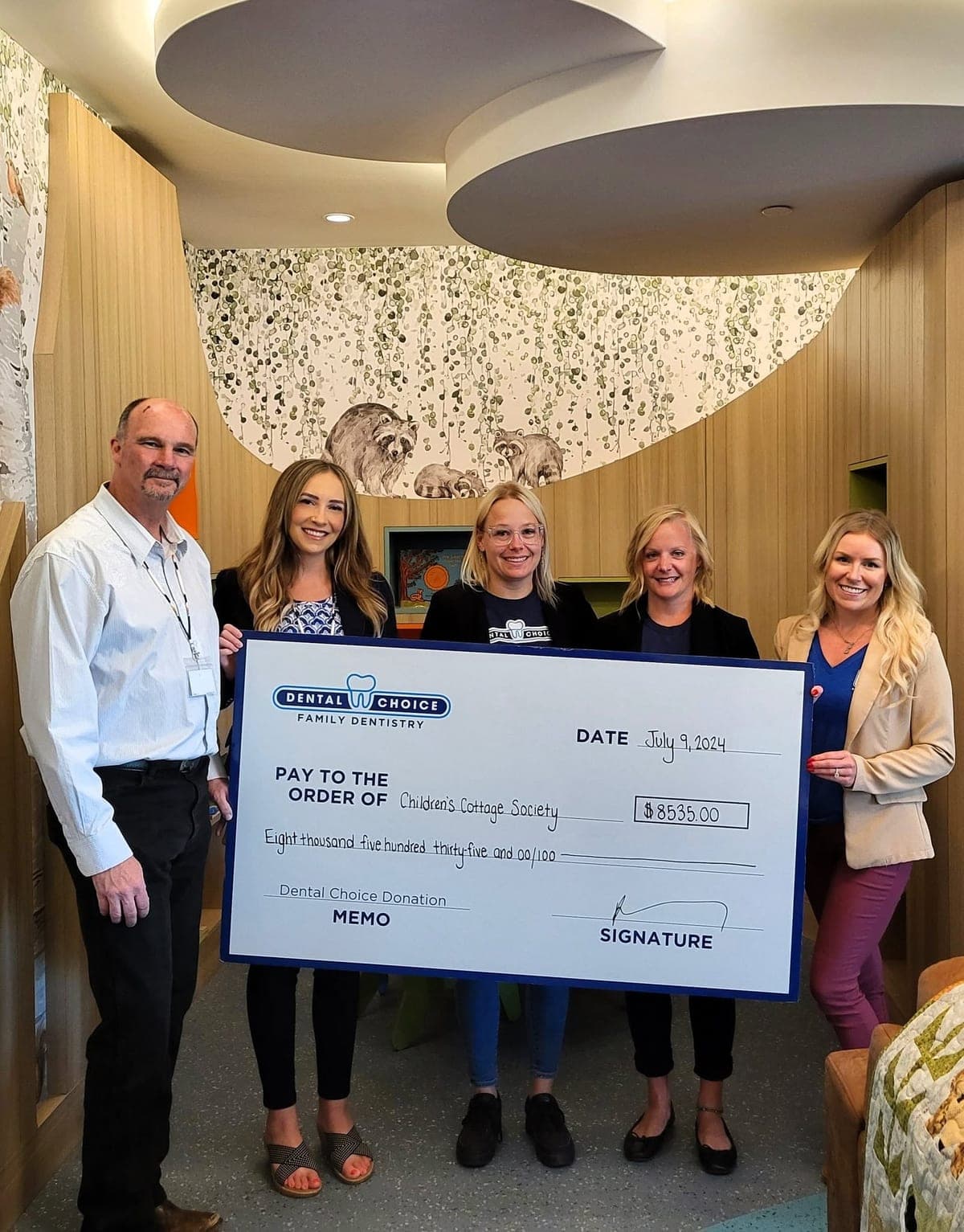 The team presenting a donation cheque to the Children’s Cottage Society