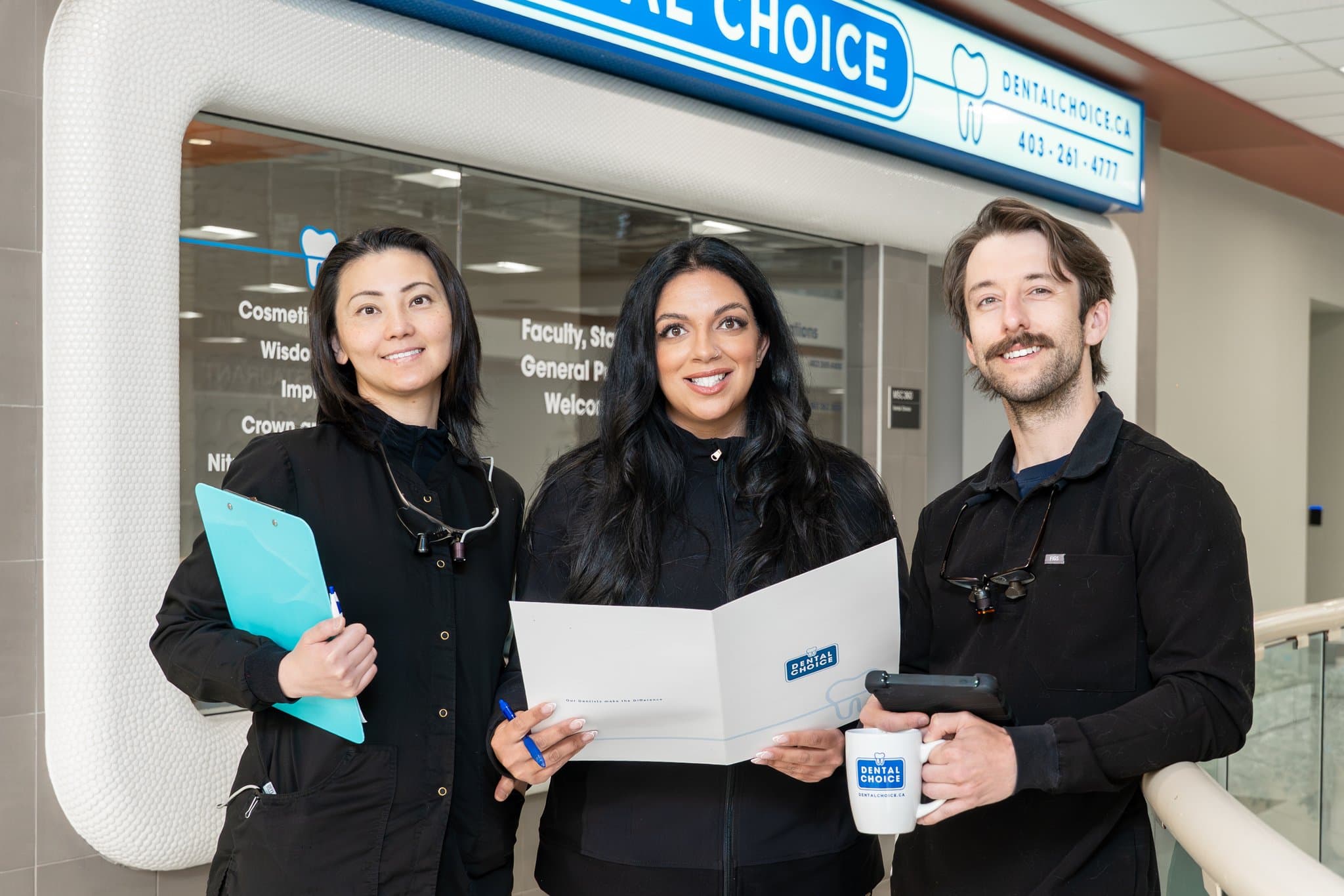 Three Dental Choice team members with patient information folders outside the University Calgary clinic