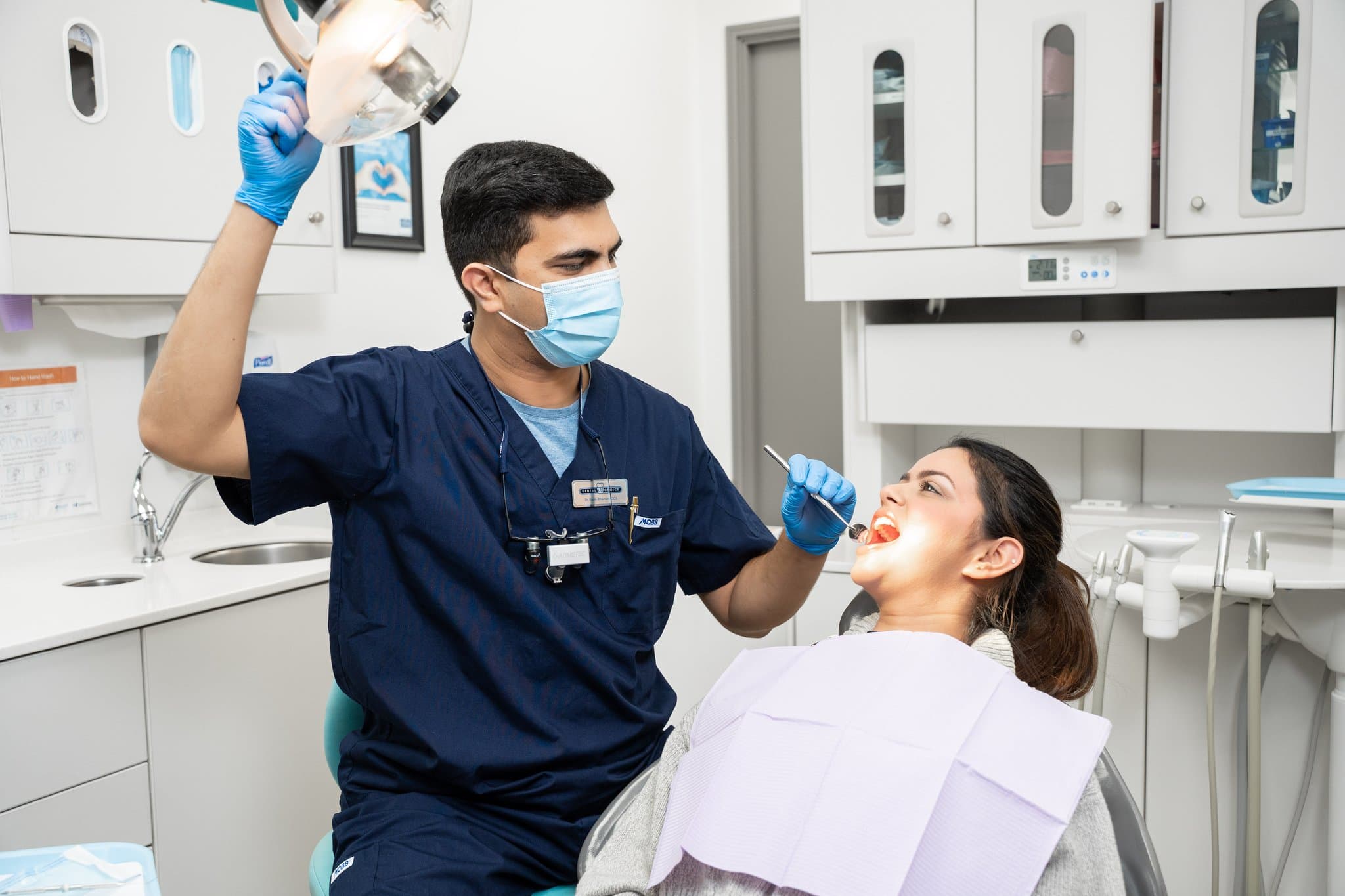A Dental Choice dentist adjusting the chair light for a patient